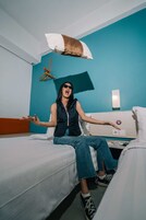 Habitación de hotel con dos camas, una pared azul y una toalla colgada.