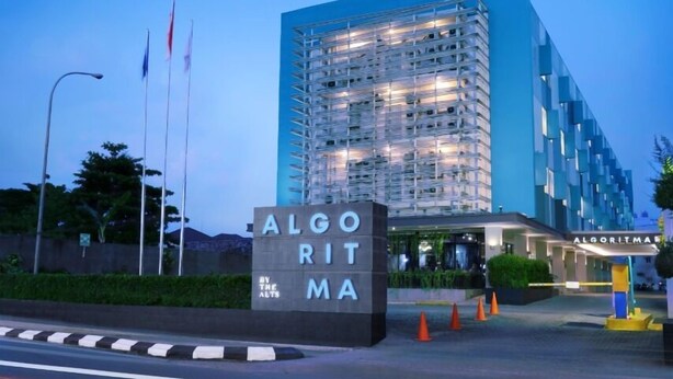 A modern hotel entrance with a sign reading "ALGOTIMA" and "BY THE ALTS".