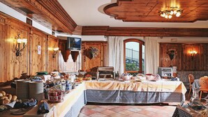 A dining area with wooden paneling, a buffet setup, and a large window with a view. - Residence Casa Gardola (Tignale)