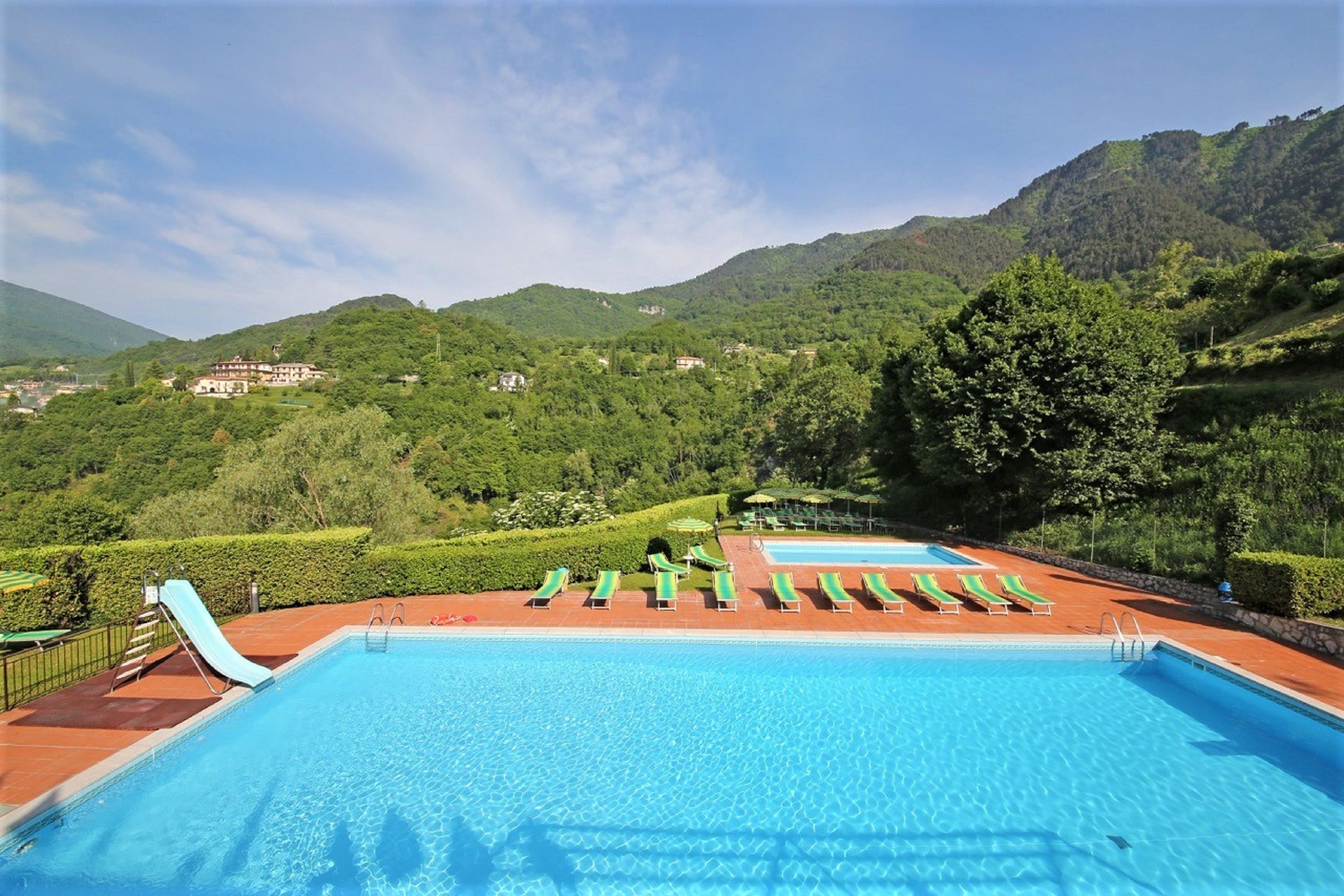 Piscina a l'aire lliure de temporada, para-sols i gandules 