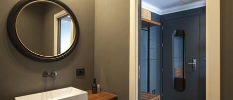 Une salle de bain moderne avec un lavabo rectangulaire, un miroir rond et un meuble-lavabo en bois.
