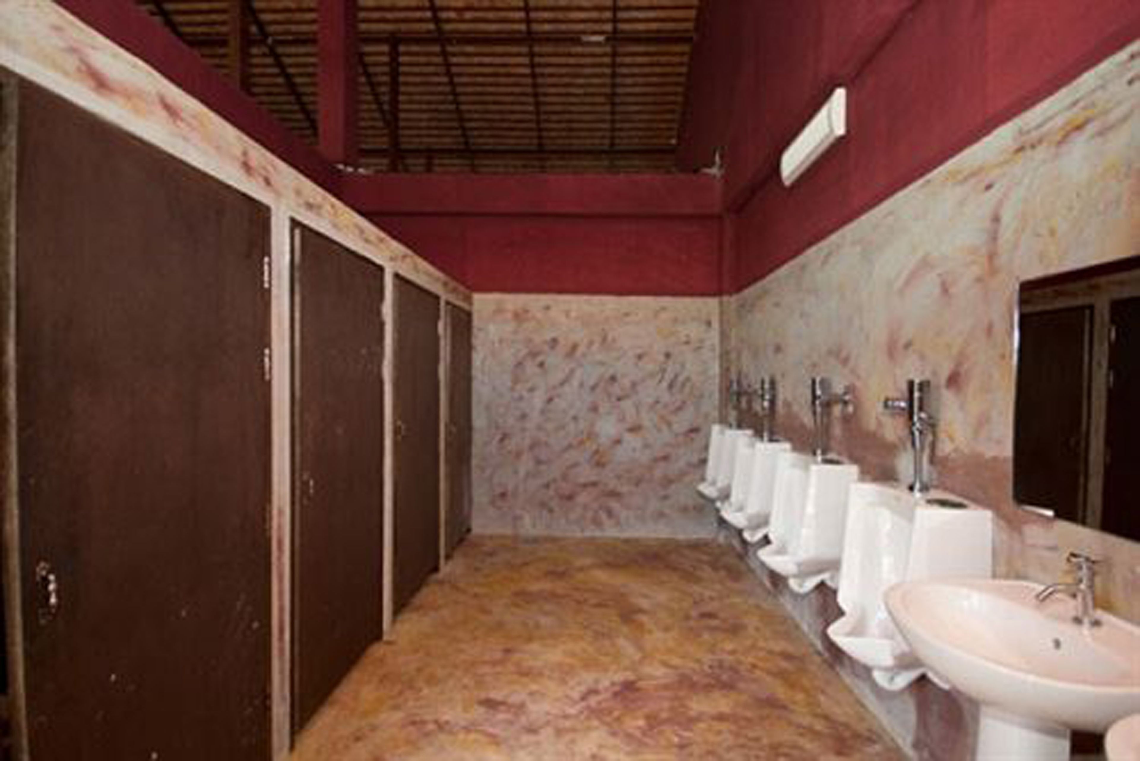 Un baño con varios lavamanos y una fila de inodoros.