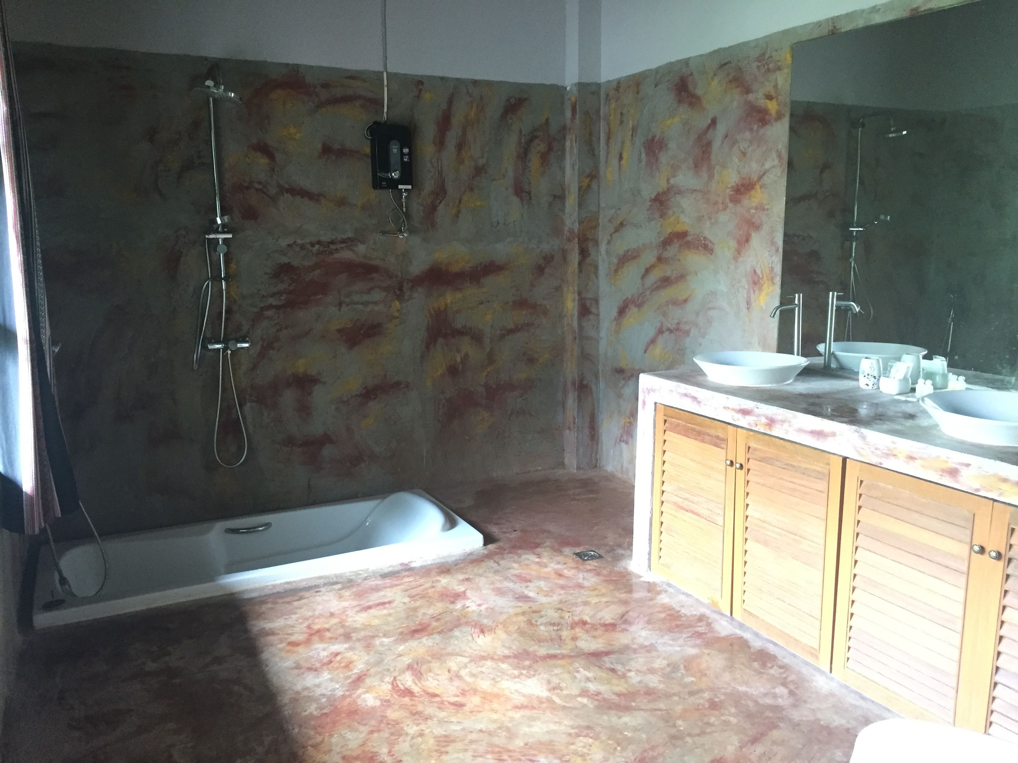 A bathroom with a bathtub, a shower, and a vanity with a mirror.