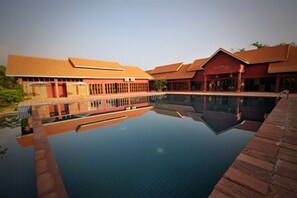 Una piscina al aire libre, sillones reclinables de piscina