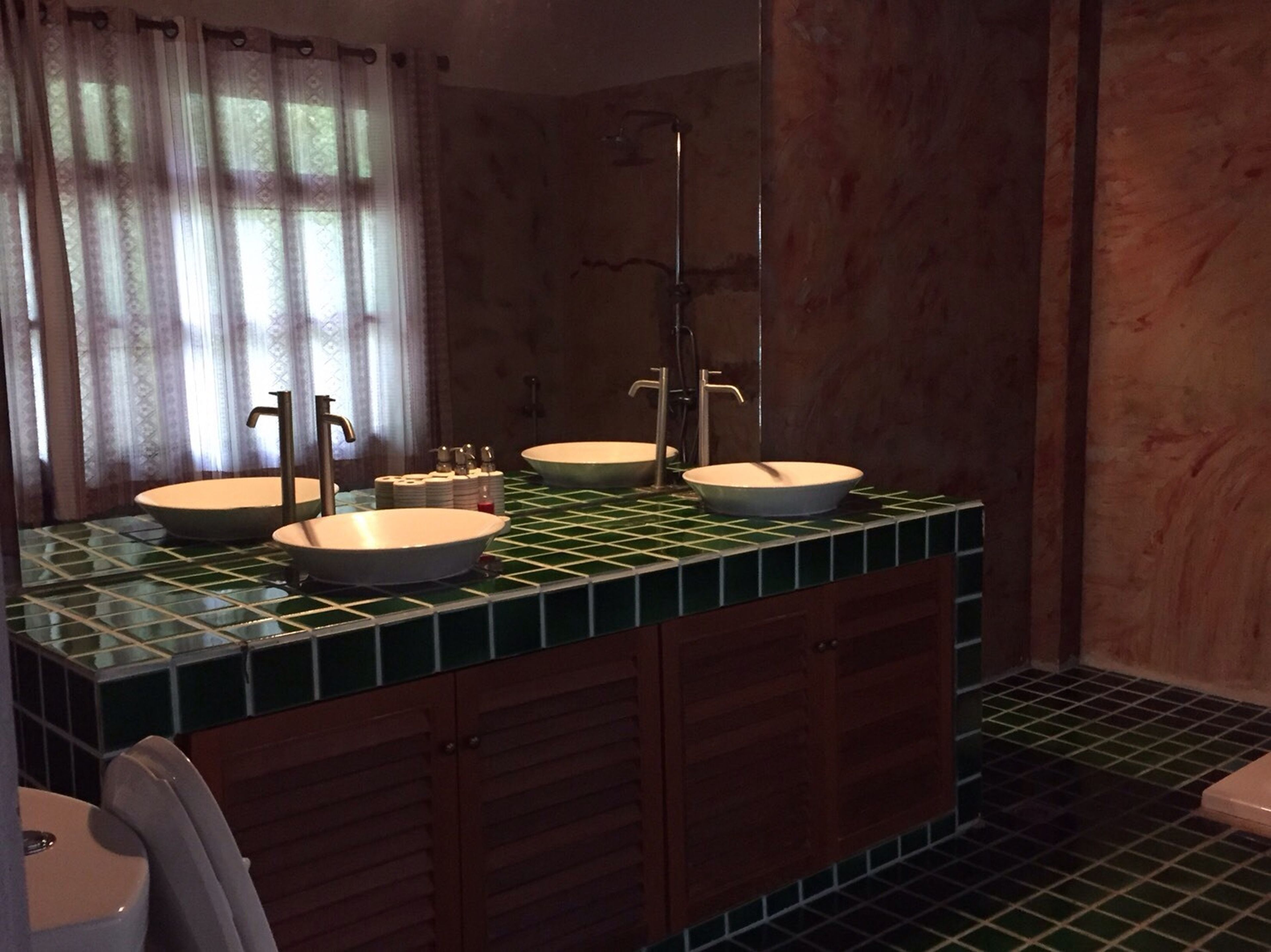 A bathroom with two sinks, a mirror, and a shower.