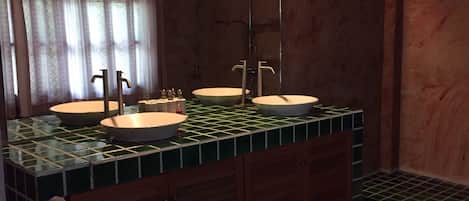 A bathroom with two sinks, a mirror, and a shower.