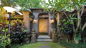 A traditional entrance with a stone archway, a wooden door, and two lanterns on either side. - Ubud Raya Villa (Ubud)