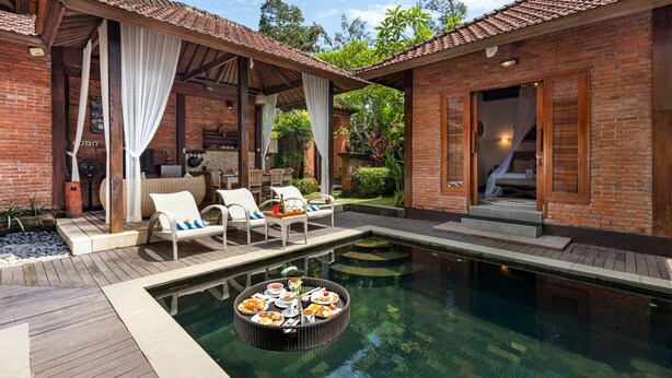 A poolside area with a dining table, lounge chairs, and a small pool. - Ubud Raya Villa (Ubud)
