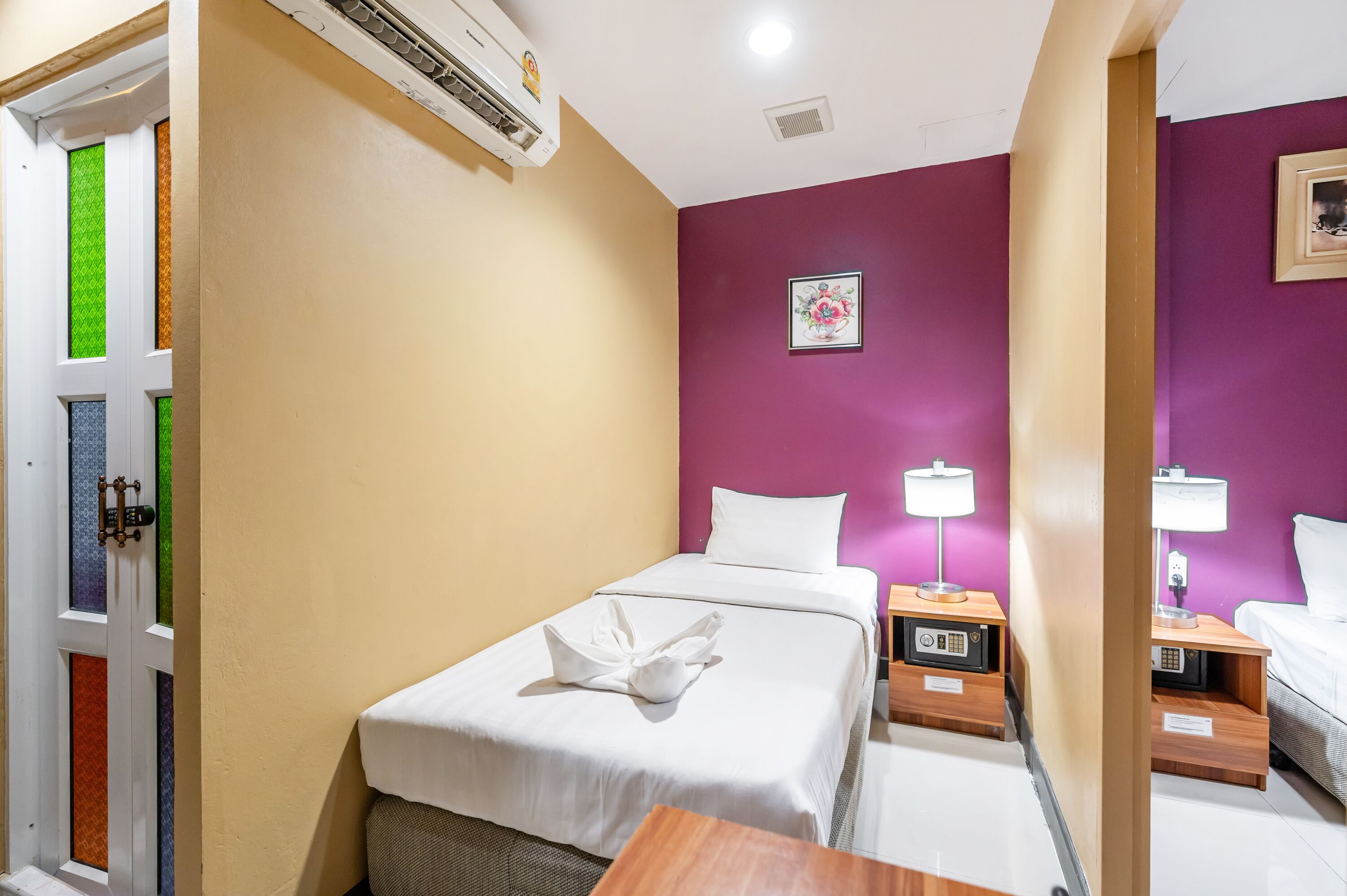 A hotel room with a bed, bedside tables, a lamp, and a picture on the wall.