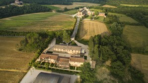 A large estate with multiple buildings, expansive fields, and a winding road connecting them. - Agriturismo San Galgano (Chiusdino)