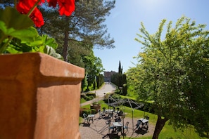 A garden patio with outdoor seating and a pathway leading to a building in the distance.