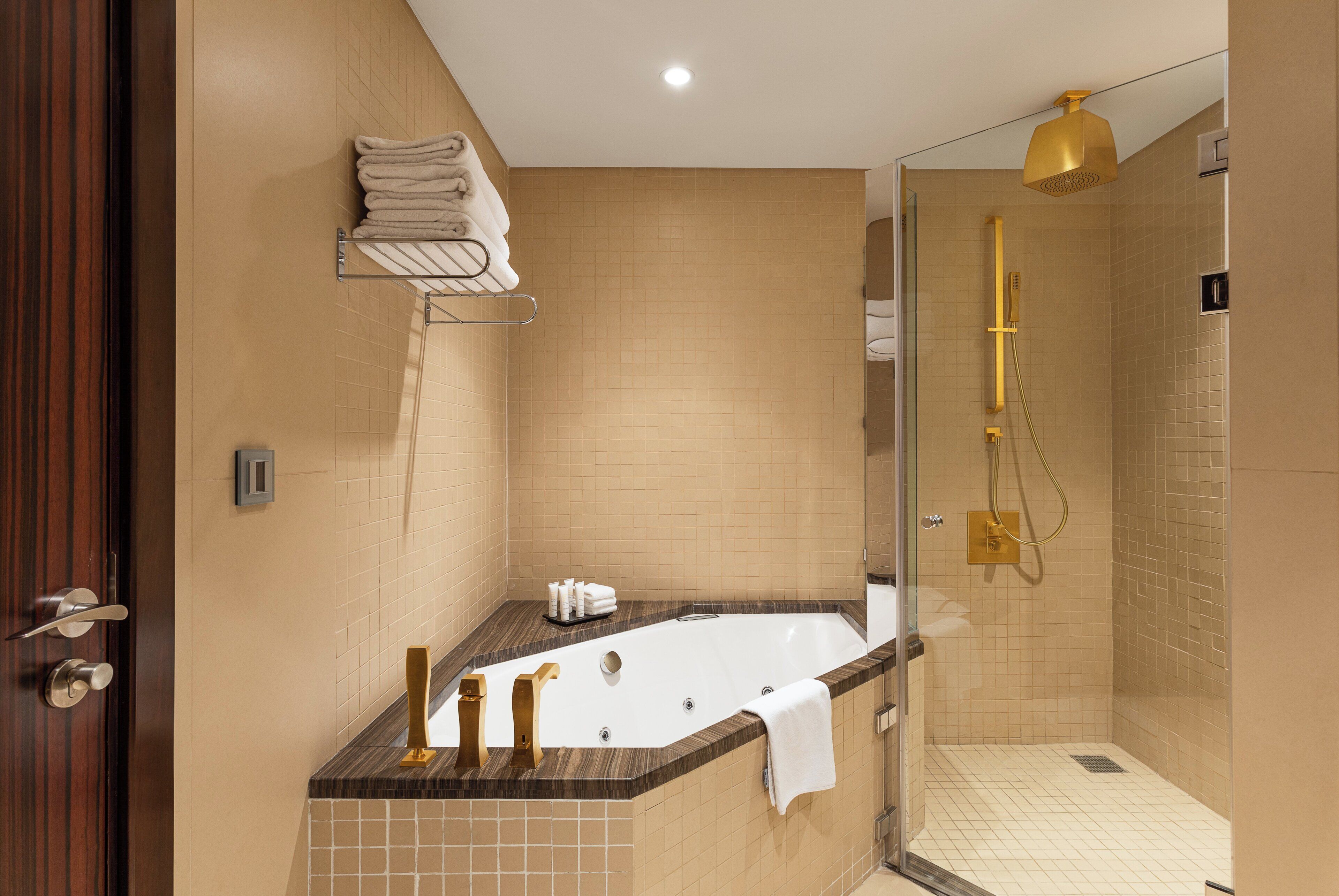 A modern bathroom with a bathtub, a shower, and a vanity with a towel rack.