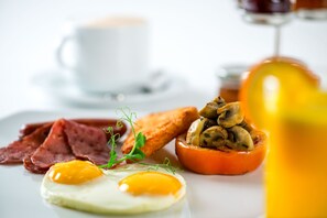 A breakfast plate with eggs, bacon, mushrooms, and toast.