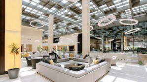 A spacious lobby with a large sectional sofa, a coffee table, and a potted plant. - Crowne Plaza Riyadh RDC Hotel & Convention by IHG (Riyadh)