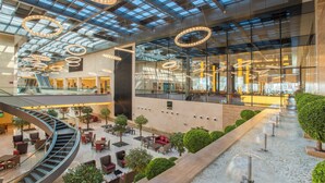 A spacious atrium with a central spiral staircase, multiple seating areas, and a water feature. - Crowne Plaza Riyadh RDC Hotel & Convention by IHG (Riyadh)