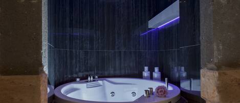 Une salle de bain moderne avec une grande baignoire, un miroir et un espace douche.