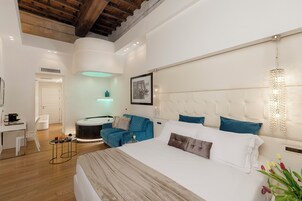 Una camera d'albergo moderna con un letto grande, una scrivania, una sedia e un tavolino con bevande.