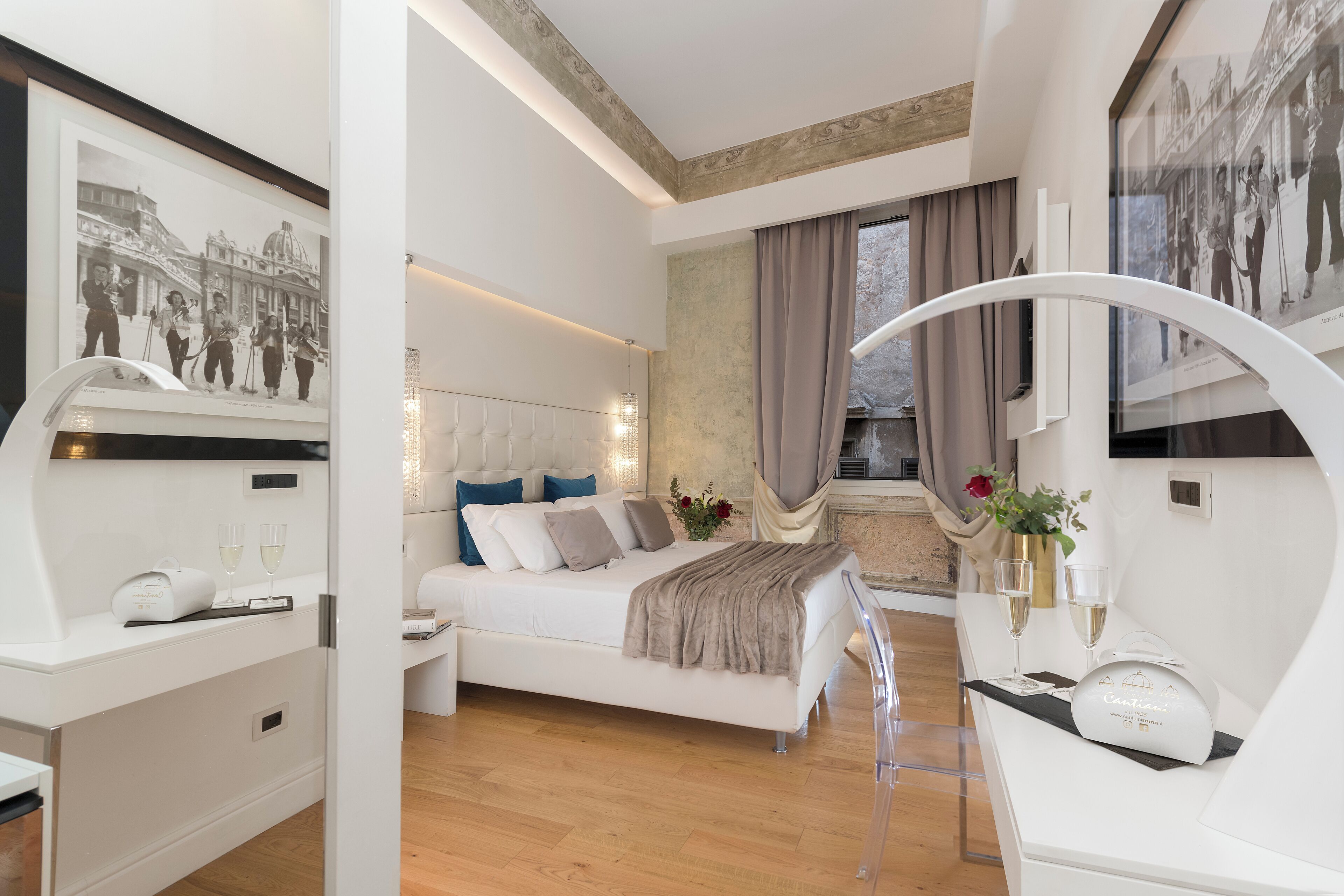 Una camera d'albergo moderna con un letto grande, un comodino con lampada, una scrivania e un'ampia finestra con tende.