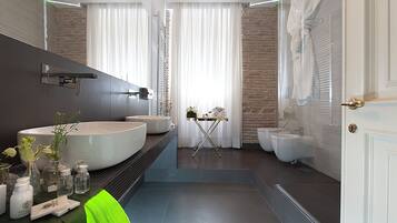 Un bagno moderno con un ampio lavandino bianco, uno specchio e un piccolo tavolino con articoli da toilette.