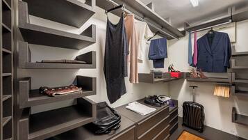 A modern closet with multiple shelves and hanging space, organized with clothing and shoes.