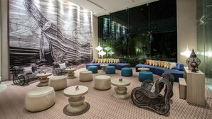 A modern lounge area with a large abstract mural, comfortable seating, and ambient lighting. - Mercure Pattaya Ocean Resort (Pattaya)