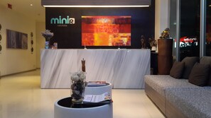 A reception area with a marble counter, a modern sofa, and a large abstract painting on the wall.