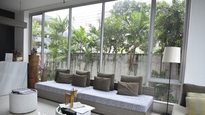 A modern living room with a sofa bed, a white coffee table, and a floor lamp.