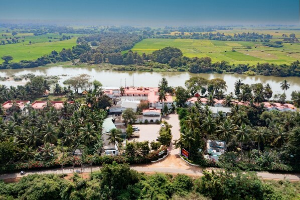 Vista aérea de un resort con varias construcciones, un río y abundante vegetación.