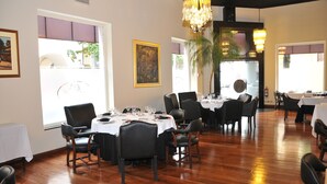 Comedor con mesas dispuestas para una comida, sillas y una araña.