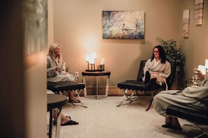 A room with two reclining chairs, a small table with a lamp, and a painting on the wall. - The Inn At Harbor Shores (Saint Joseph)