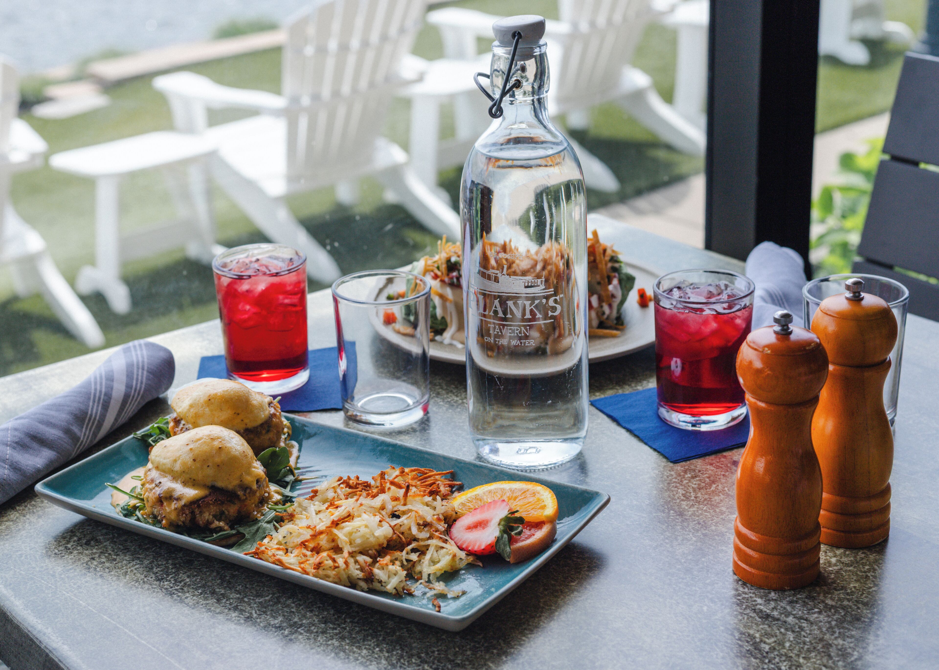Una mesa con comida, bebidas y una botella.