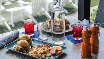 Una mesa con comida, bebidas y una botella.