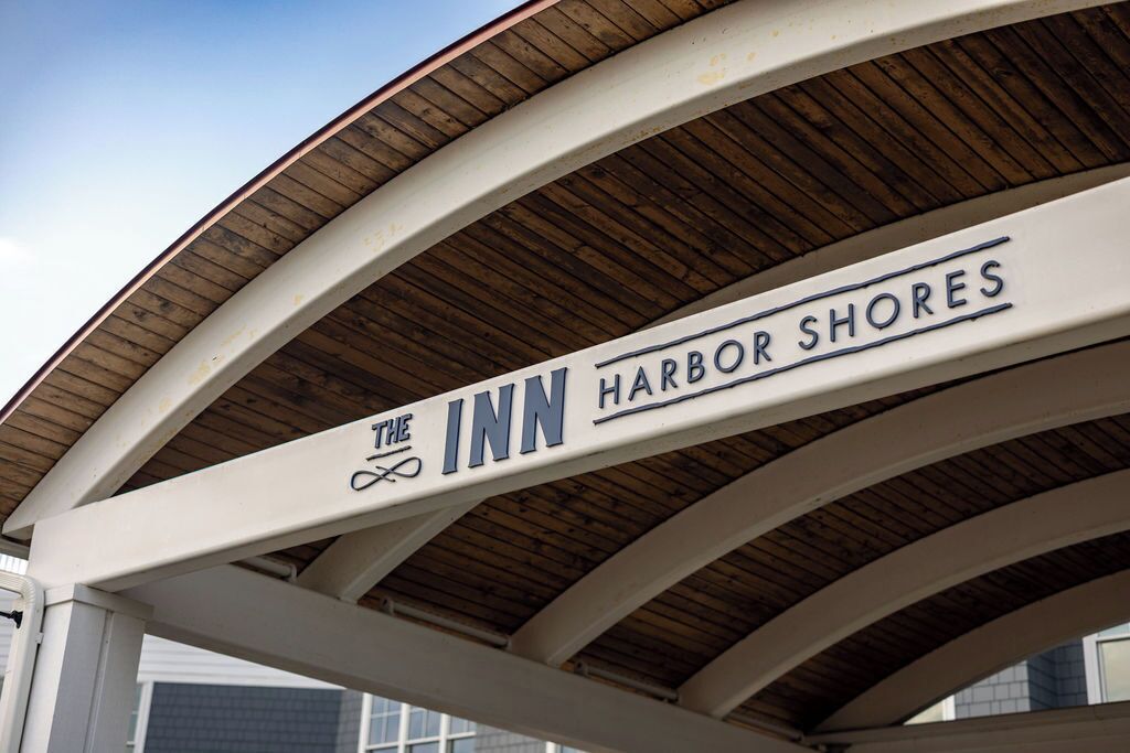 Placa de 'The Inn Harbor Shores' com estrutura de telhado curva.