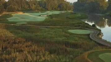 Golfers can enjoy a serene game amidst lush greenery and a tranquil lake.