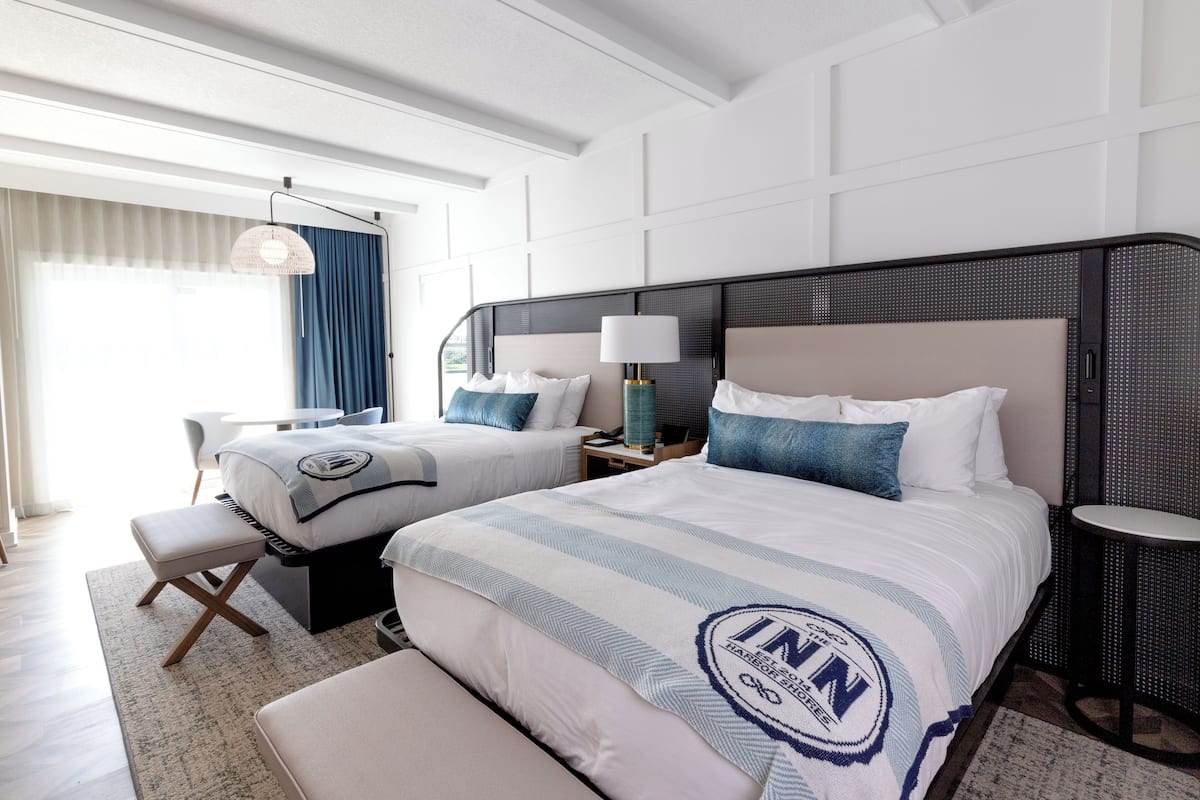 Ein Hotelzimmer mit zwei Betten, einem Schreibtisch und einem Stuhl.