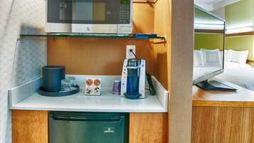 A compact kitchenette with a microwave, coffee maker, and refrigerator.