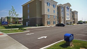 Un hôtel à plusieurs étages, doté d’une façade en pierre, de nombreuses fenêtres et d’un parking avec des flèches indiquant le sens de la circulation.