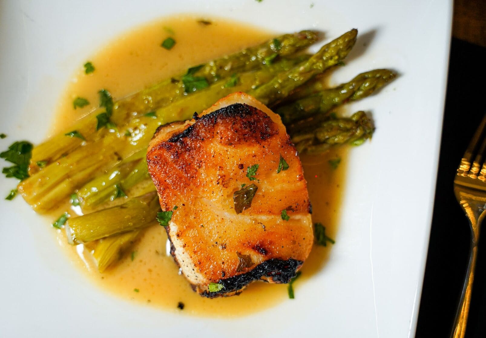 A plate with grilled chicken and asparagus.