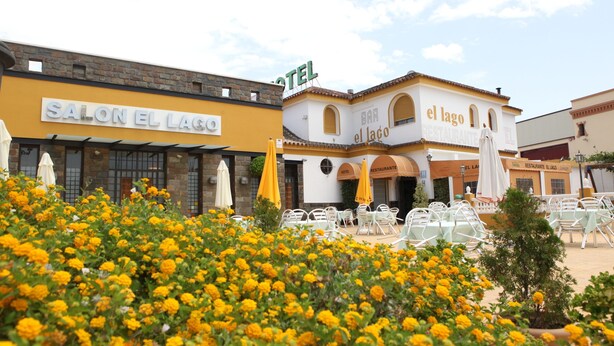 Ein Hotel mit gelber Fassade und einem Schild mit der Aufschrift "SALON EL LAGO".