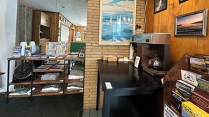 Un comptoir d’accueil avec une carte, des œuvres d’art encadrées et des brochures d’information.