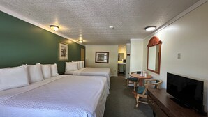 Une chambre d’hôtel avec deux lits, une télévision, un bureau et une chaise.