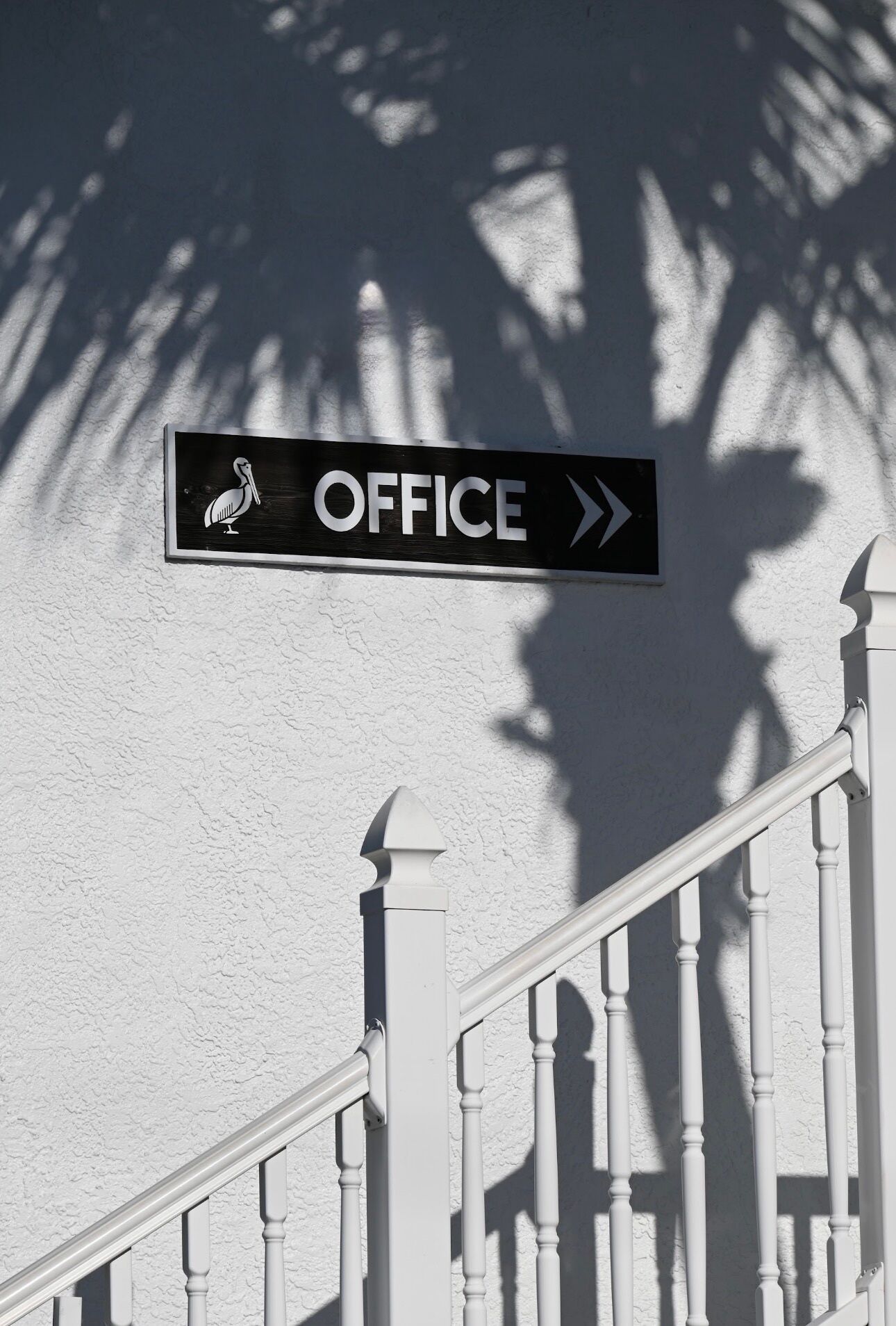 A staircase with a sign indicating an office direction.