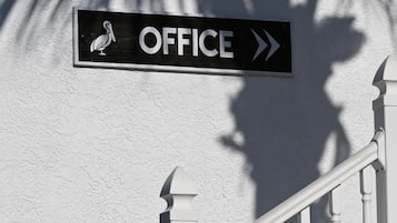 A staircase with a sign indicating an office direction.