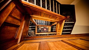 A wooden staircase with a geometric patterned wall in the background. - Hotel Gosford (Gosford)