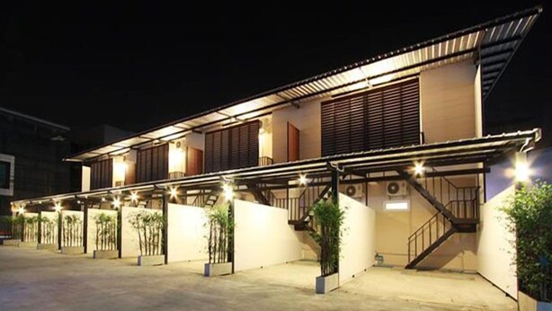 A modern building with multiple covered areas and a staircase leading to an upper level. - Bearing 26 Hotel (Samut Prakan)