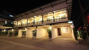 A multi-story hotel with a covered outdoor area, multiple balconies, and potted plants. - Bearing 26 Hotel (Samut Prakan)