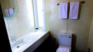 A bathroom with a sink, toilet, and a mirror. - Bearing 26 Hotel (Samut Prakan)