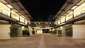 A spacious, well-lit indoor area with multiple levels and balconies, featuring a central open space and potted plants. - Bearing 26 Hotel (Samut Prakan)