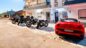 A building with a sign reading "RESIDENCIAL" and a red sports car parked in front. - Residencial Luso Espanhola (Elvas)