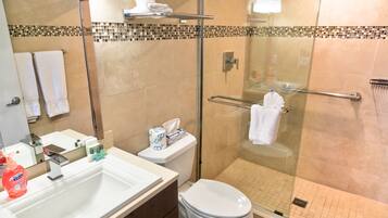 A modern bathroom with a glass-enclosed shower, a white sink, and a toilet.